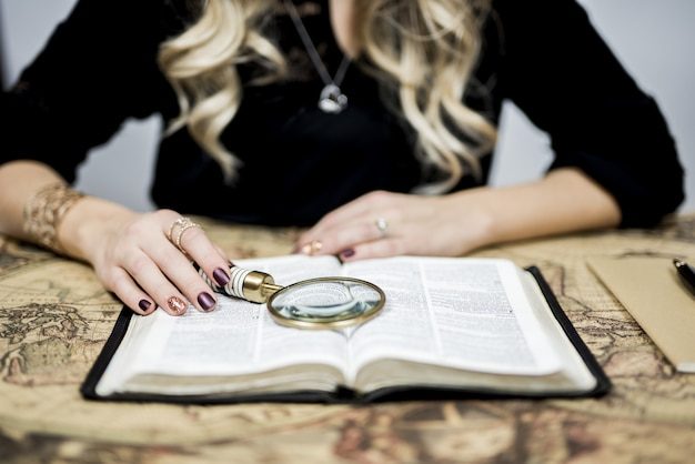 Persona con lupa revisando un texto de cerca